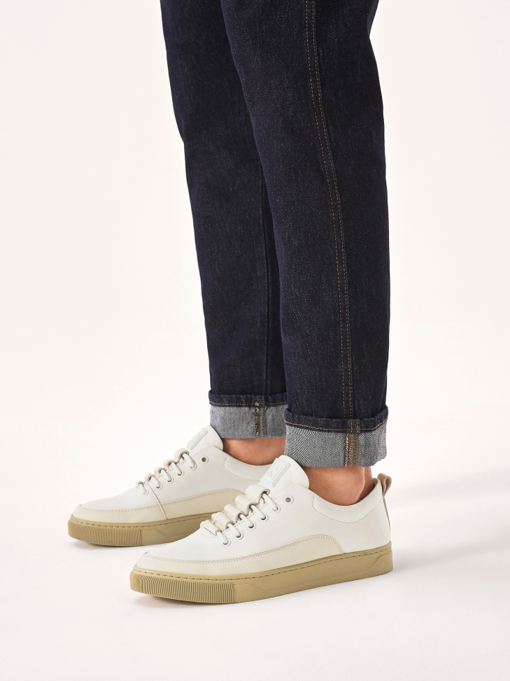 White leather sneakers on a beige sole  AJAKS