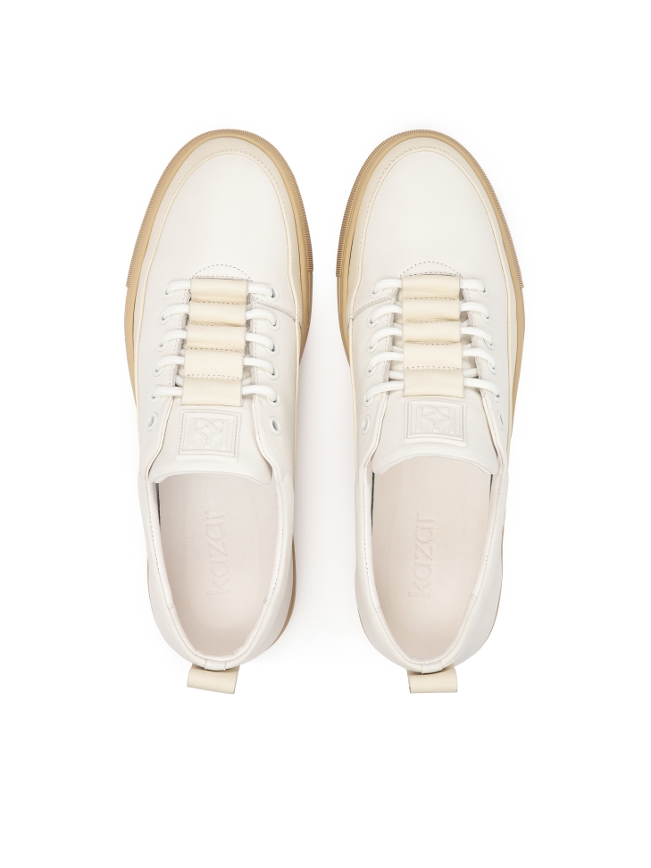 White leather sneakers on a beige sole  AJAKS
